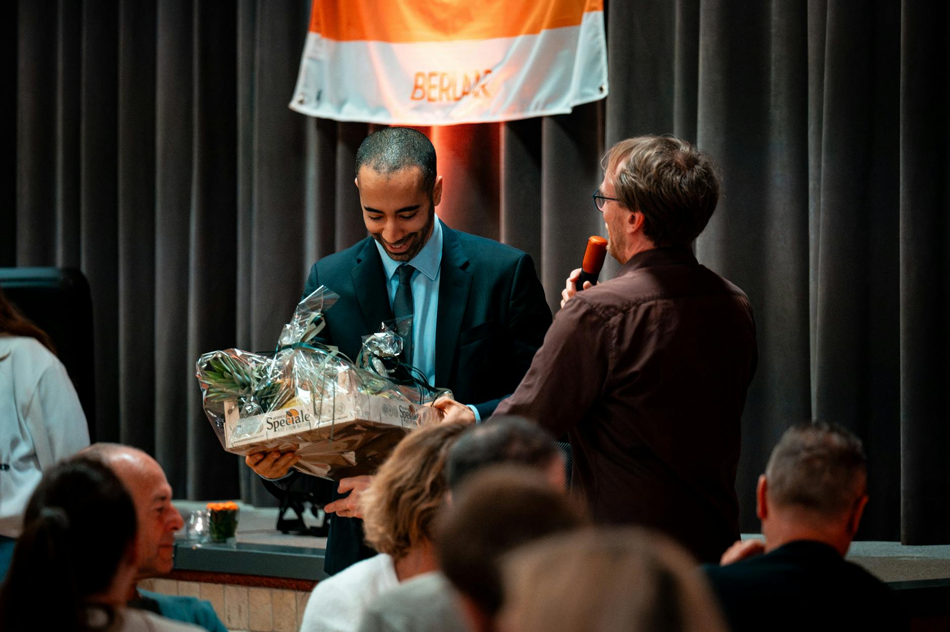Mężczyzna odbiera kosz prezentowy podczas firmowej gali nagród
