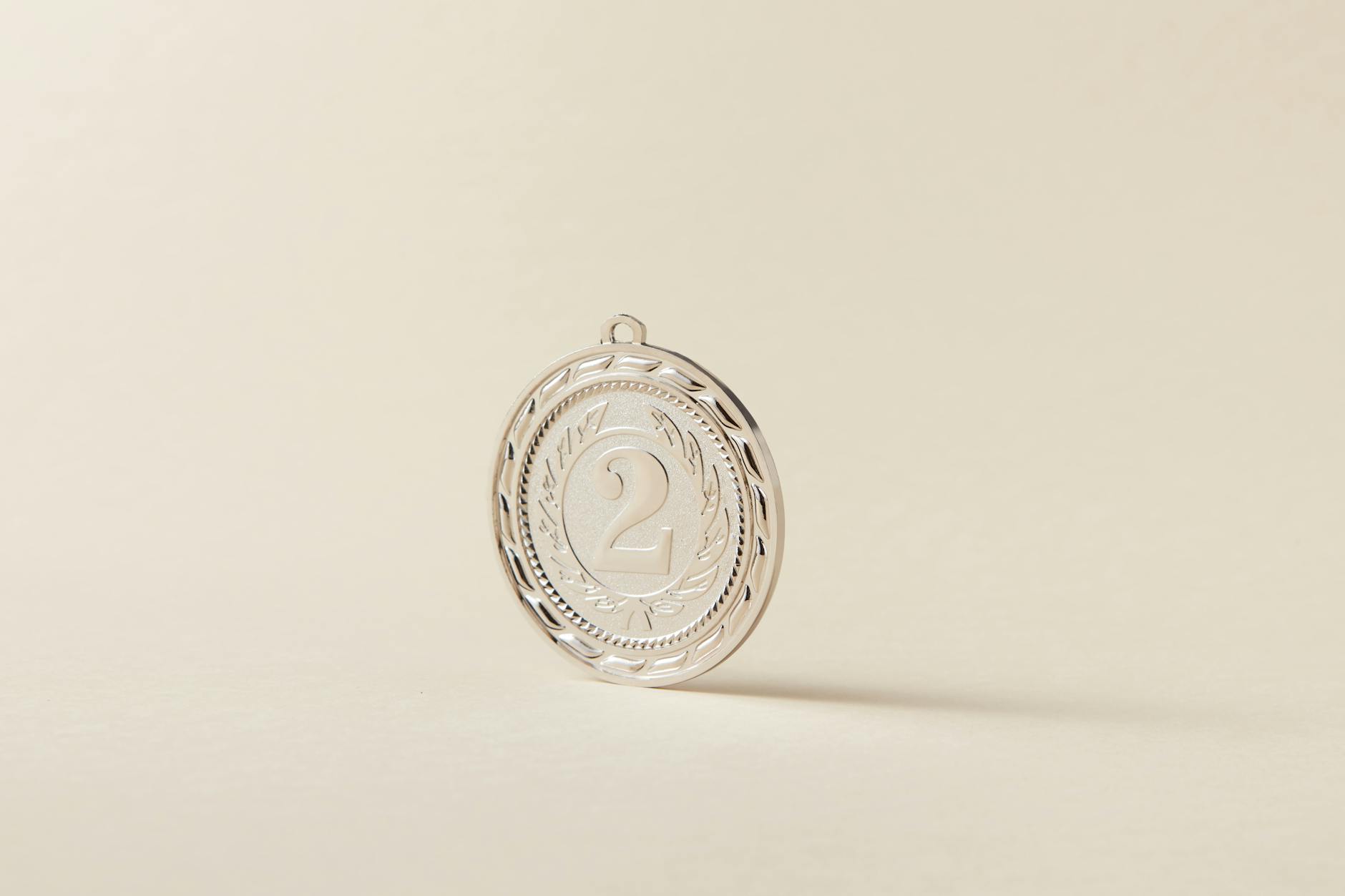 Srebrny medal z cyfrą 2 na jasnym, neutralnym tle