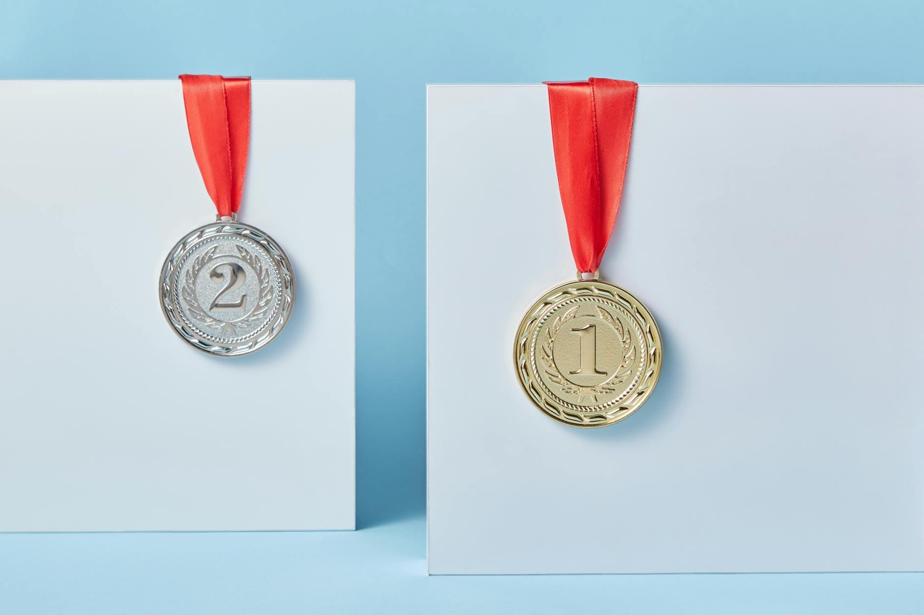 Złoty i srebrny medal na czerwonych wstążkach na niebieskim tle