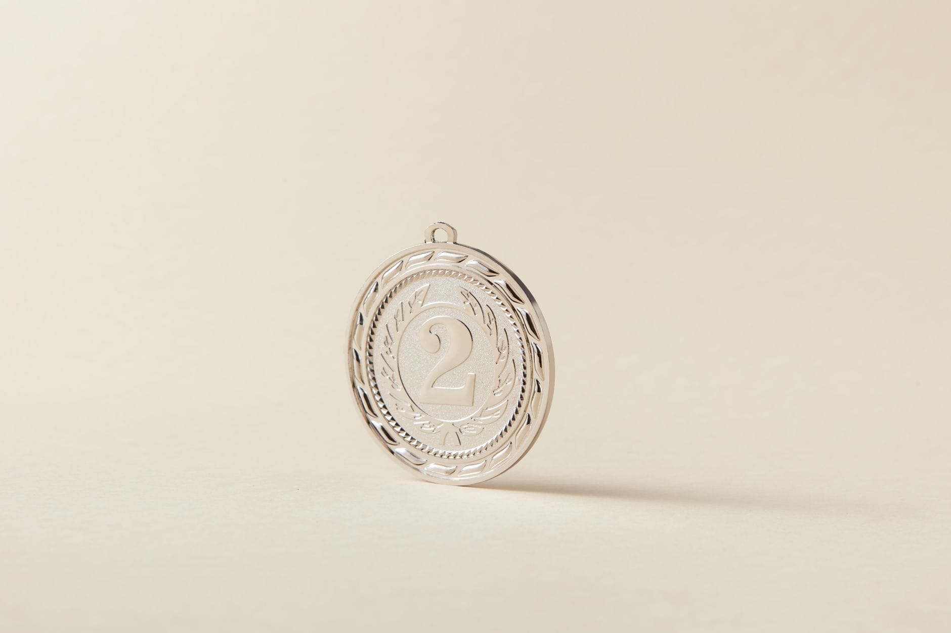 Srebrny medal sportowy z numerem dwa na jasnym tle